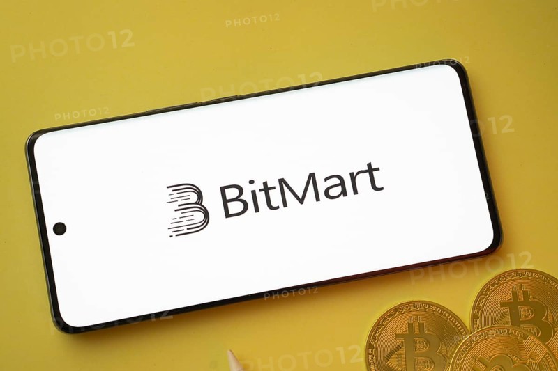 Dhaka, Bangladesh- 15 June 2025: Bitmart logo on smartphone screen near Bitcoin coin and QR code on blue background