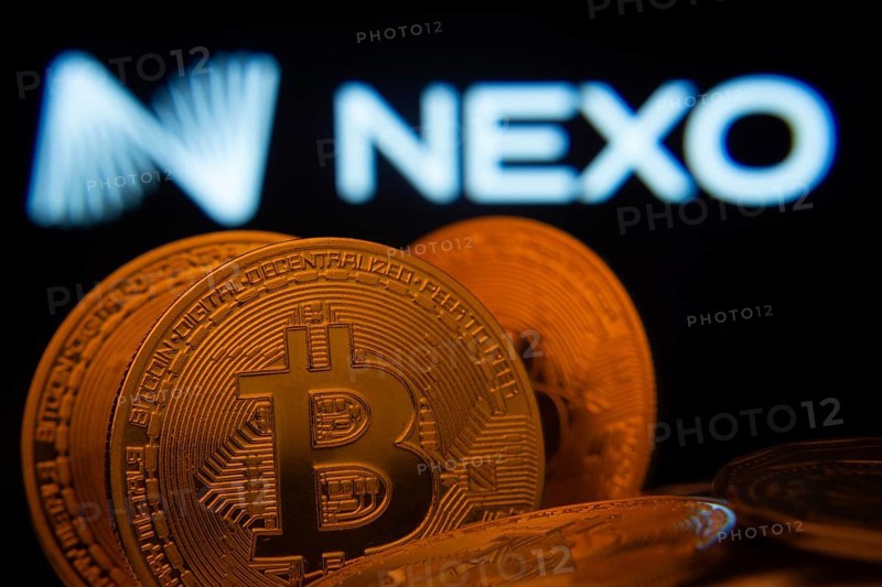 Dhaka, Bangladesh- 06 Sep 2025: Close-up of Bitcoin coins with the Nexo logo visible on a screen in the background