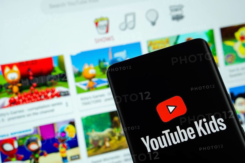 Dhaka, Bangladesh - 06 Sep 2025: The logo of Youtube Kids is displayed on a smartphone screen, and the website is visible on a computer screen in the background