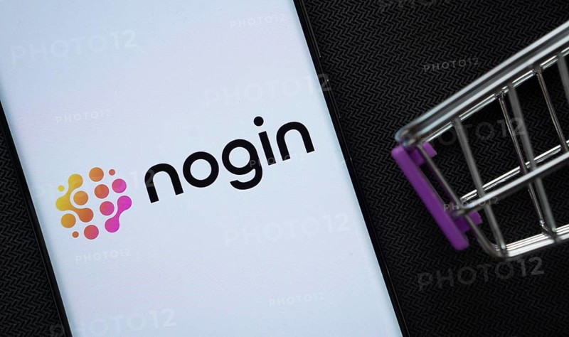 Dhaka, Bangladesh- 03 July 2025: A smartphone displaying the nogin logo next to a miniature shopping cart on a background