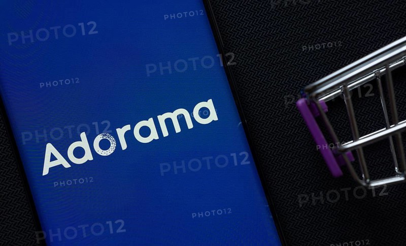 Dhaka, Bangladesh- 03 July 2025: A smartphone displaying the Adorama logo next to a miniature shopping cart on a background