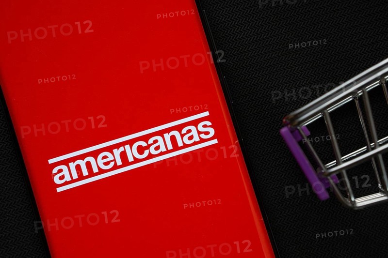 Dhaka, Bangladesh- 03 July 2025: A smartphone displaying the Americanas logo next to a miniature shopping cart on a background