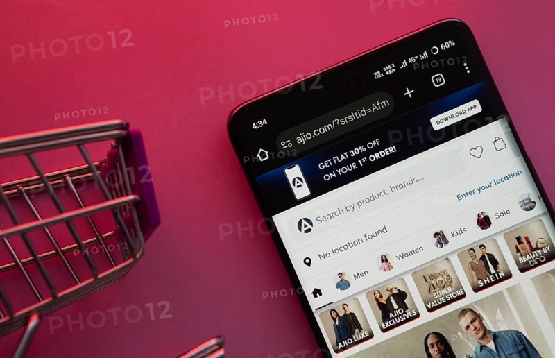 Dhaka, Bangladesh- 23 June 2025: A smartphone displaying the AJIO website with a shopping cart is shown on a vibrant background