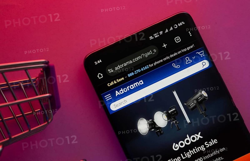 Dhaka, Bangladesh- 23 June 2025: A smartphone displaying the Adorama website with a shopping cart is shown on a vibrant background