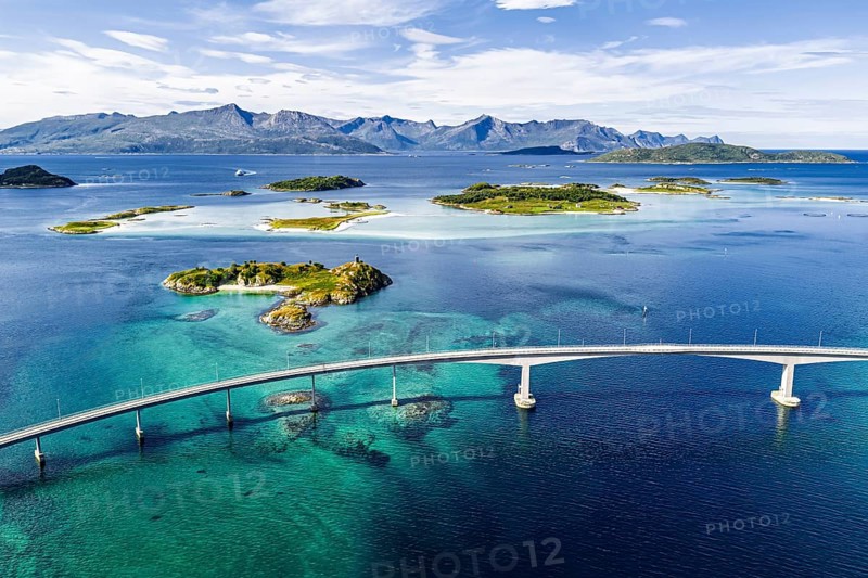 Sommaroy Bridge connecting Kvaloya Island to Sommaroy Island, small islands, mountain range in the back, turquoise water, aerial view, Norway