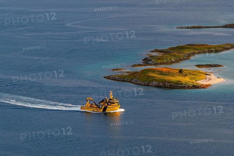 Boat passing islands near Sommaroy Bridge, warm light at sunset, aerial view, Norway