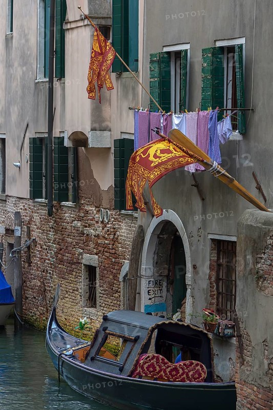 Flying flags of the Republic of Venice on a residential building, a gondola on the canal, Venice, Venice, Italy
