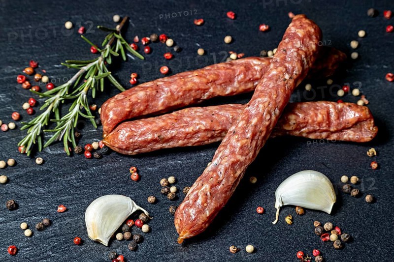 Rustic composition with salami, rosemary, peppercorns and garlic cloves, crunchy Pfefferbeiser sausage