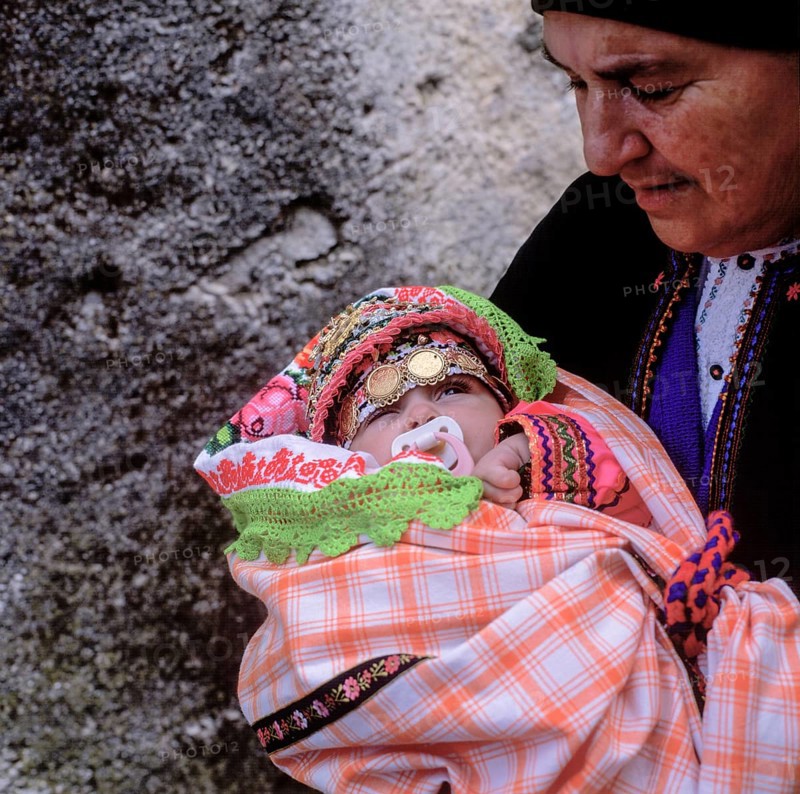 Easter Sunday, grandmother holding little girl in festive traditional dress, Olymbos, Karpathos, Dodecanese, Greece