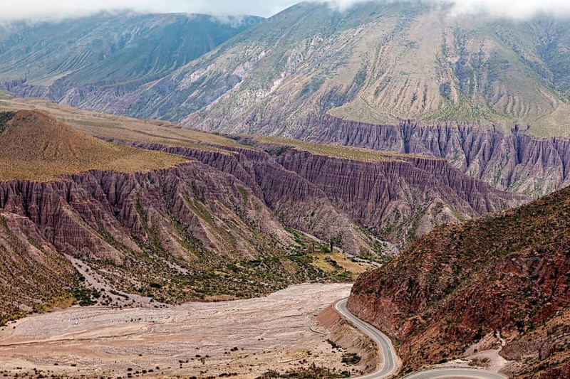 Deep valley with steep slopes in a bare and dry desert landscape, the landscape and colorful rock formations of the Quebrada de Cafayate near Salta in Argentina