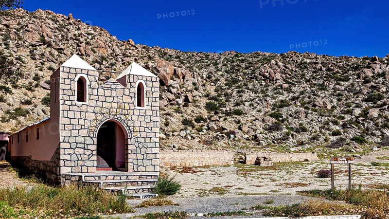Small chapel in a wide desert landscape with rocky surroundings under bright blue sky, The chapel in Santa Rosa de Tastil near Salta in Argentina