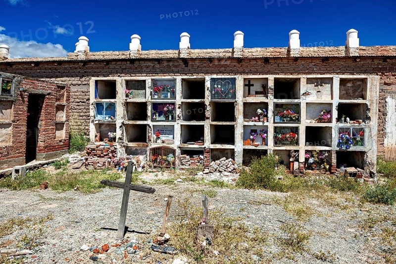 Weathered wall with grave niches and cross in an old cemetery, The cemetery of Cachi in Argentina