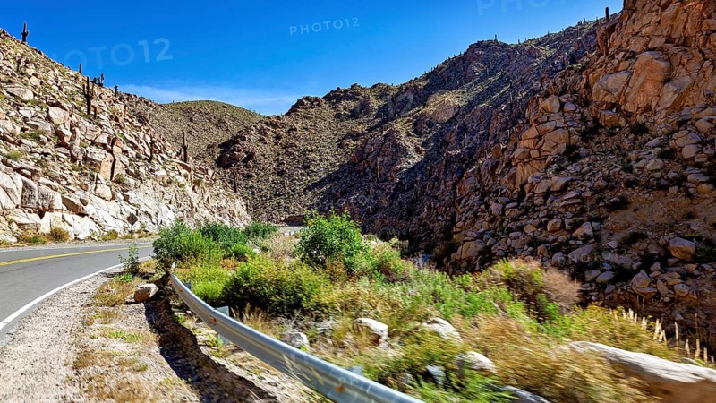 Road winds through rocky gorge in a sunny desert landscape, roads through the Quebrada de Cafayate countryside near Salta in Argentina