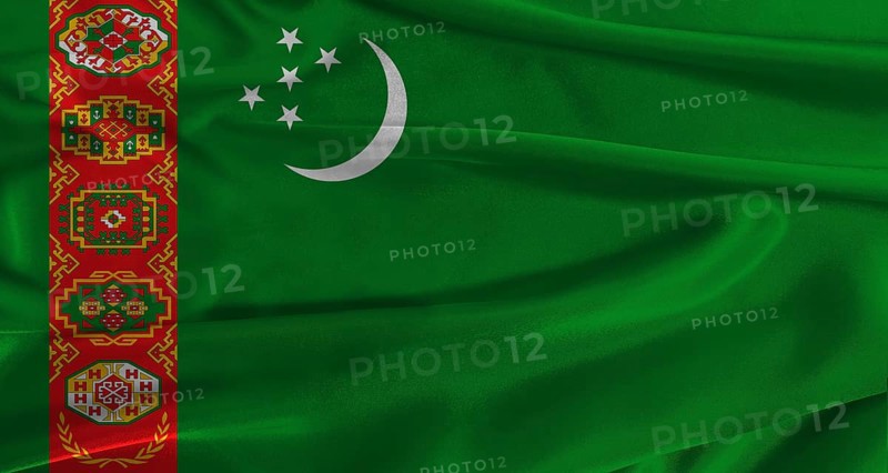 Flag of Turkmenistan with fabric textured background. Close up of National flag of Turkmenistan with realistic texture