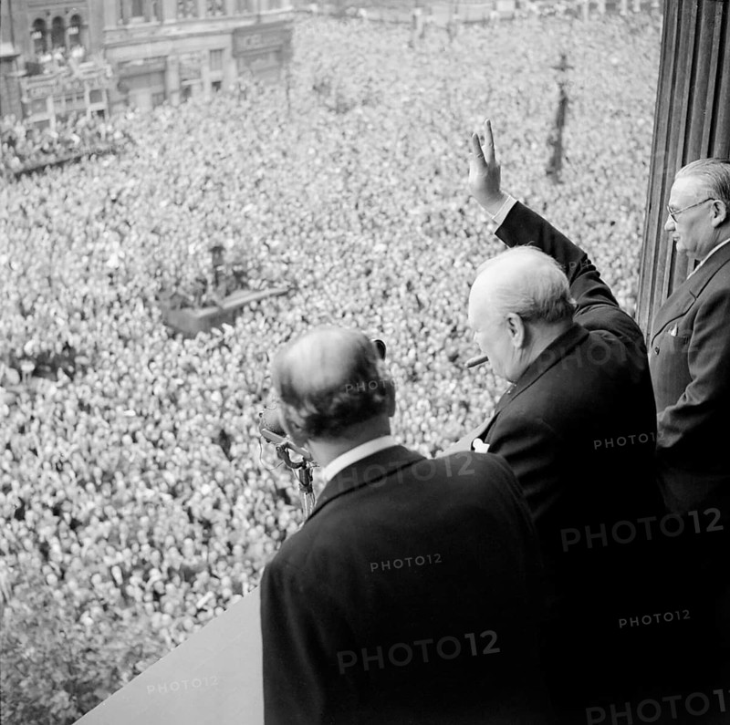Winston Churchill, important statesman, particularly during the Second World War. Prime Minister, politician, writer and Nobel Prize winner for literature greets cheering crowd celebrating with the Victory sign in Whitehall, London. They celebrate the end of the war and the defeat of National Socialism, Great Britain Contemporary history, historical