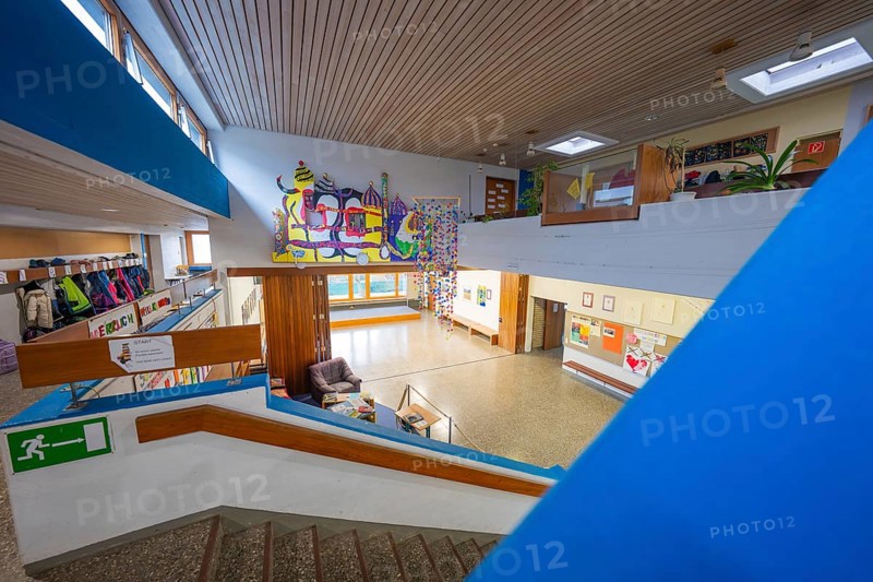 An interior with a staircase, decorated with art and a pleasantly illuminated wooden ceiling, Schlehengäu Grund Schule Gechingen, Calw district, Germany