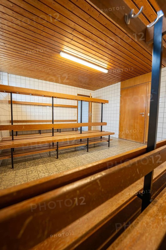 An empty changing room with wooden benches and simple lighting, Schlehengäu Grund Schule Gechingen, Calw district, Germany