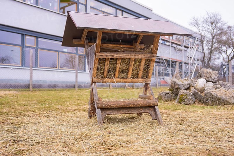 Wood hay rack on a hay covered meadow next to stones, Schlehengäu Grund Schule Gechingen, Calw district, Germany