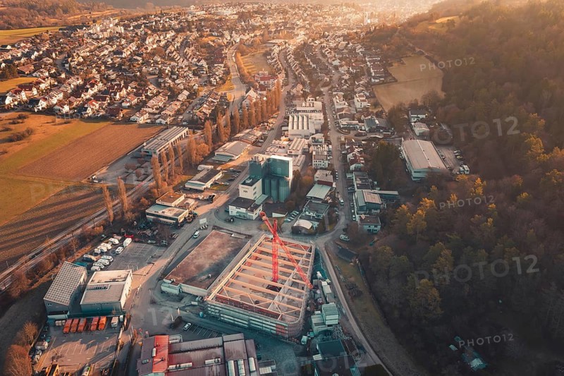 Panoramic view of an urban building area with crane and surrounding residential areas at sunset, Rewe new building, Aidlingen, Böblingen district, Germany