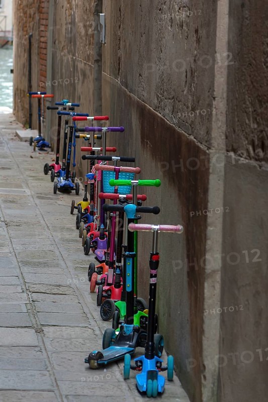 Parked children's scooters in front of a kindergarten, Venice, Veneto, Italy