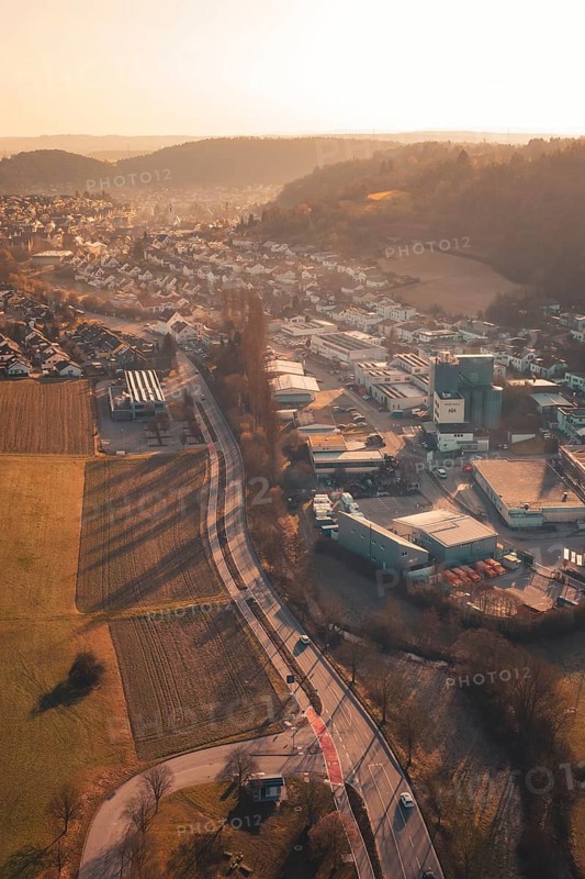 Urban and industrial zones alongside fields and hills in sunset light, Aidlingen, Böblingen District, Germany