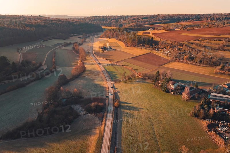 Fields and a road extending through a rural landscape under sunny skies, Aidlingen, Böblingen District, Germany