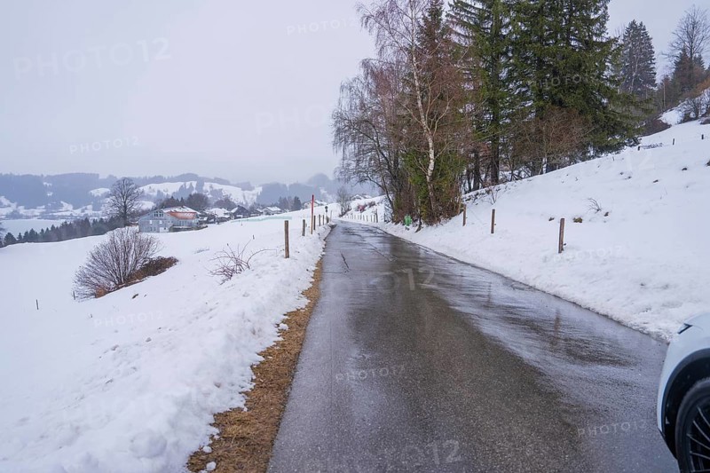 Snowy street with trees on the sides and quiet winter atmosphere, specialist clinic for psychosomatics and psychotherapy, Hochgrat Clinic, Stiefenhofen, Bavaria, Germany