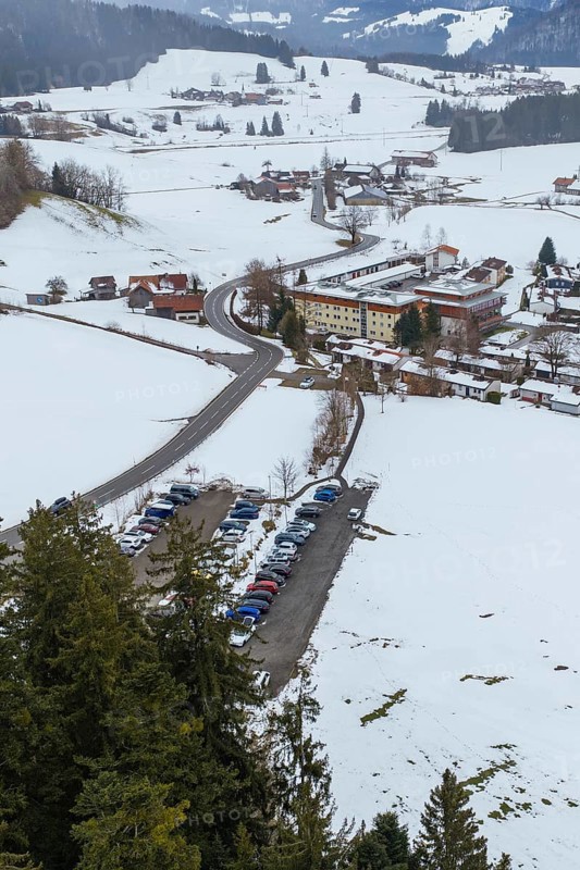 Snowy village with parking lots and picturesque mountains viewed from afar, specialist clinic for psychosomatics and psychotherapy, Hochgrat Clinic, Stiefenhofen, Bavaria, Germany