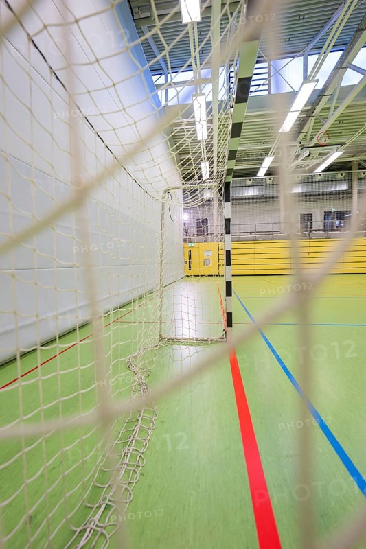 A handball goal and net in a large empty sports hall from a side view, Handball, Calw, Germany