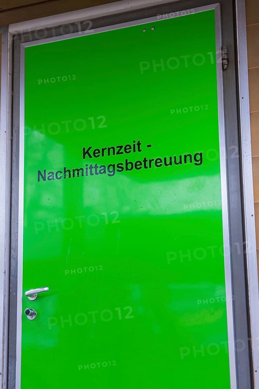 Green door with inscription for core time afternoon care, easy entrance, homework supervision, Schlehengäu elementary school Gechingen, Calw district, Germany