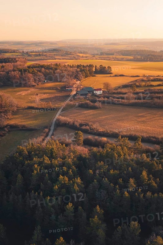 Fields and farm surrounded by forests at dusk, warm colors create a peaceful atmosphere, Gechingen, Calw district, Germany