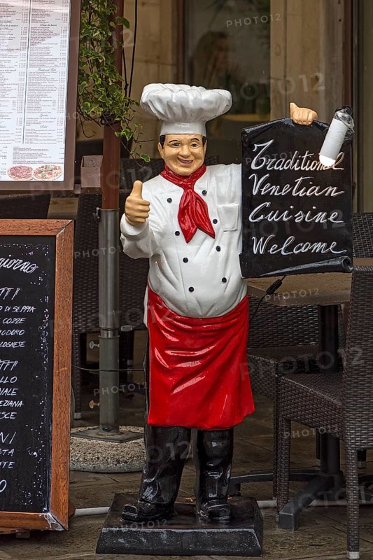 Chef as an advertising character with an offer in front of a restaurant, Venice, Veneto, Italy