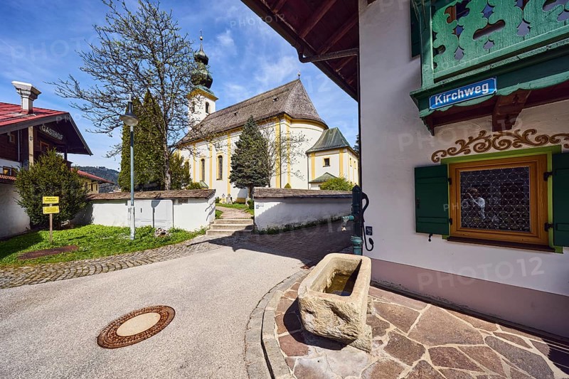 St. Michael church, pump with well trough, building, general development, street sign, wall with passage, stairs, lawn, path, trees, blue sky, cirrus clouds, cirrostratus clouds, Kirchweg, Inzell, district of Traunstein, Bavaria, Germany