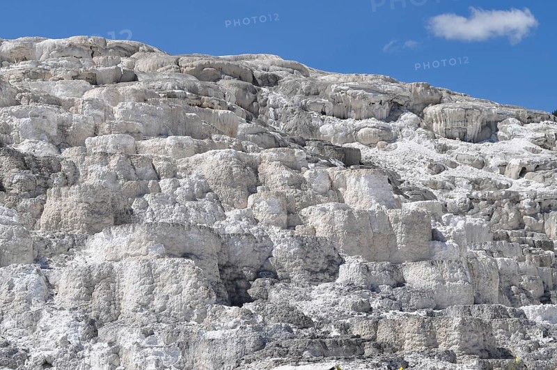 White, layered volcanic deposits under blue sky, Yellowstone National Park, Wyoming, USA