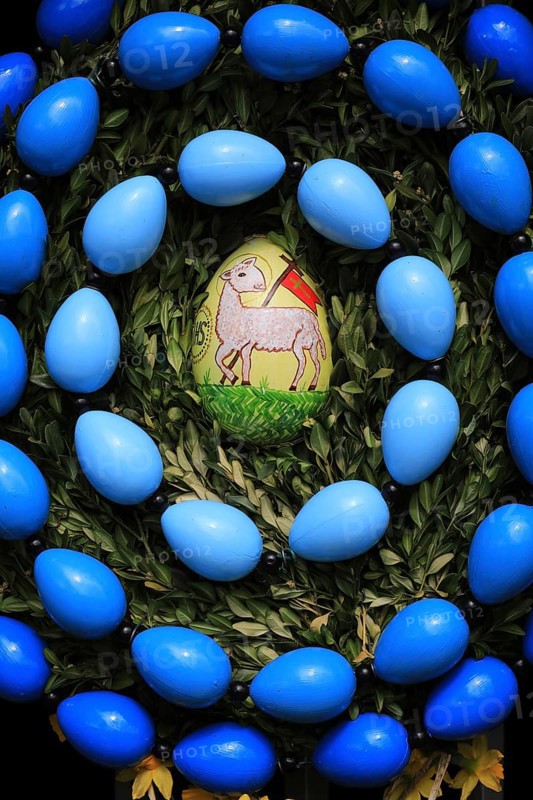 Easter fountain in Tiefenpölz, Markt Heiligenstadt, Franconian Switzerland, Bamberg district, Upper Franconia, Bavaria, Germany, decorated Easter egg with a lamb surrounded by blue eggs and leaves