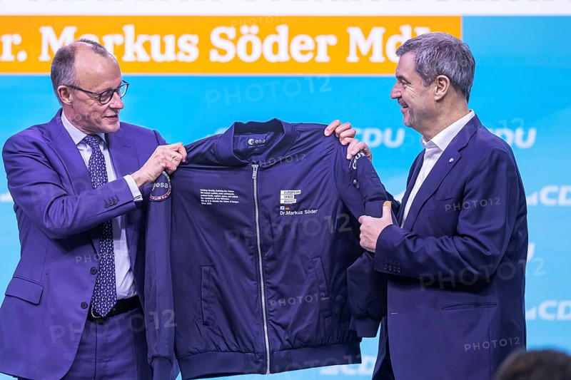38th Federal Party Congress of the CDU of Germany in Stuttgart. Greetings from Markus Söder, party leader of the sister party CSU and Minister-President of the Free State of Bavaria. Federal Chancellor Friedrich Merz hands over an esa astronaut jacket to the guest speaker because of Söder's space visions. He is also an avowed fan of the cult film Star Trek. Stuttgart, Baden-Württemberg, Germany