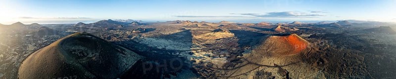 Picturesque volcanic landscape with volcanic craters and lava fields in morning light, Montaña Negra volcano, Caldera Colorada and Volcán de Las Nueces, Los Volcanes Natural Park, aerial view, Lanzarote, Canary Islands, Spain