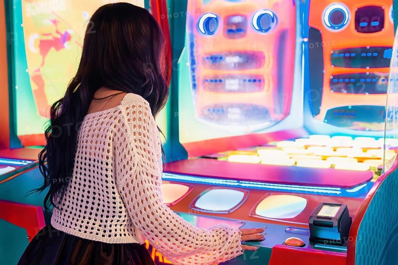 Girl enjoys her time playing at a vibrant, colorful arcade game The bright lights and lively atmosphere capture the excitement and fun of gaming
