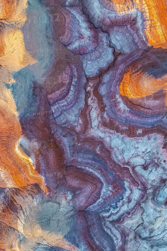 Stunning aerial view of vibrant bentonite formations in Utah, showcasing unique swirling patterns and rich earthy tones. This natural wonder highlights geological beauty