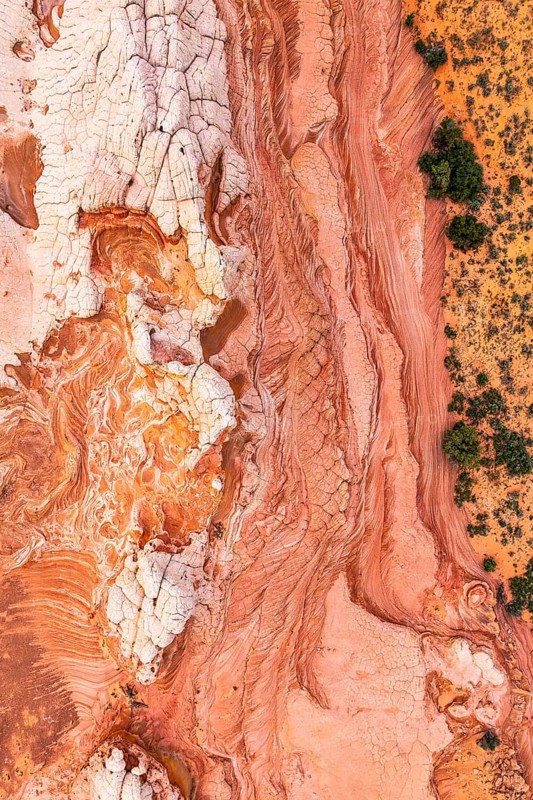 Stunning top-down view of intricate red and white rock patterns in a desert landscape, showcasing nature's abstract art