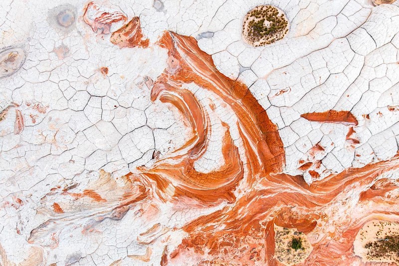 This stunning aerial photograph captures the intricate details of abstract red and white rock formations, showcasing a naturally artistic and textured landscape