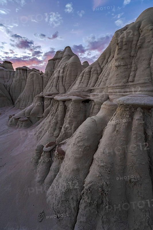 Striking geological formations at twilight in Bisti/De-Na-Zin Wilderness, New Mexico, USA, showcasing the unique beauty of sedimentary rock layers