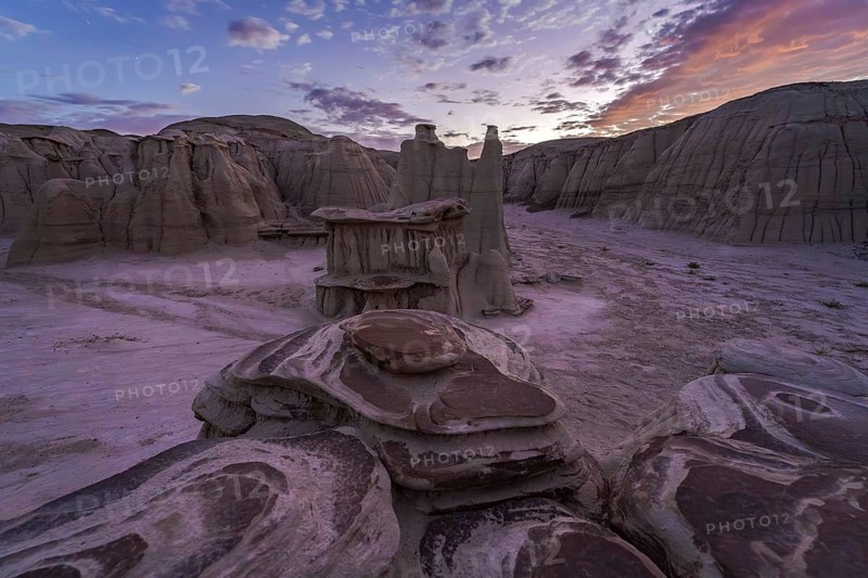 Dusk falls over the unique sandstone formations of the Bisti/De-Na-Zin Wilderness in New Mexico, showcasing the natural beauty and otherworldly landscape