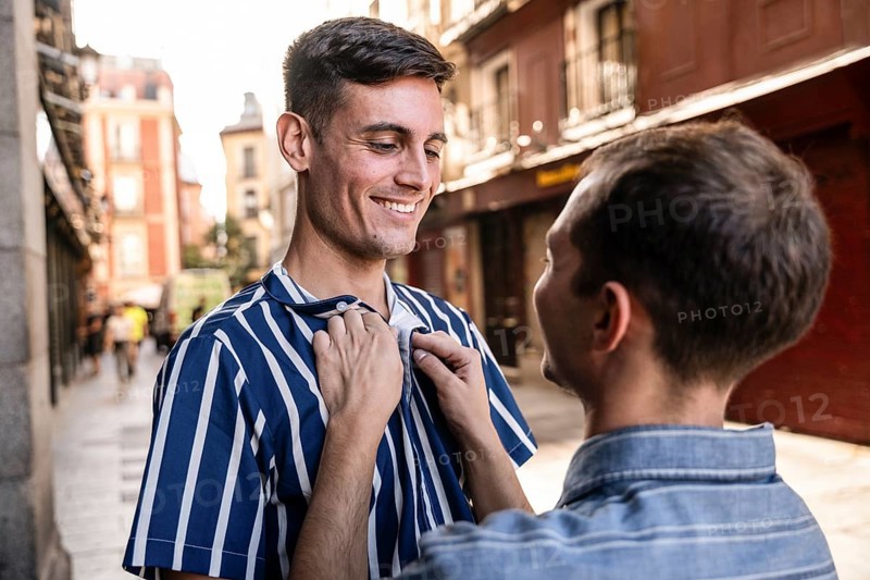 A gay couple shares a tender moment on the streets of Madrid. Capturing love and connection in a vibrant urban setting, this image celebrates LGBTQIA+ pride and unity