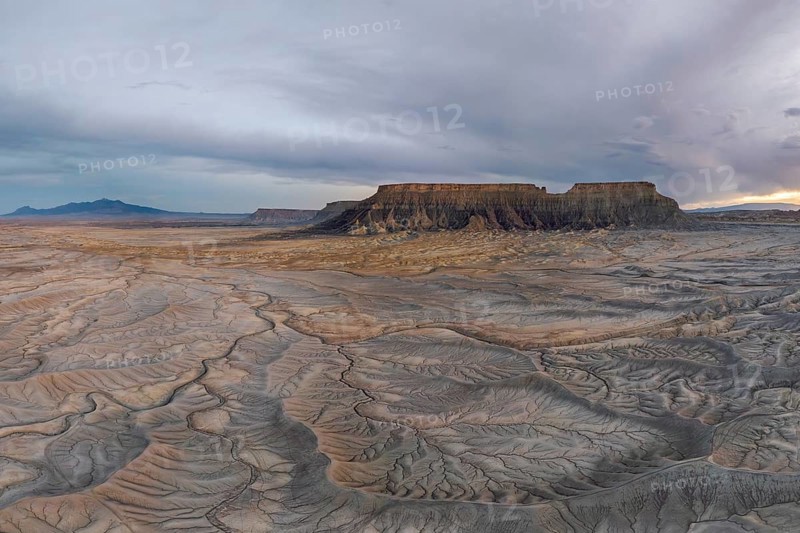 Explore the vast, rugged desert landscape featuring unique geological formations under a dramatic sky in Hanskville, Utah. The earthy textures depict nature raw beauty and timelessness of USA