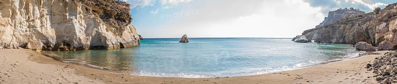Panoramic image of the secluded beach Gerontas on the Island of Milos in Greece, showcasing tranquil turquoise waters bordered by white cliffs and a pristine sandy beach