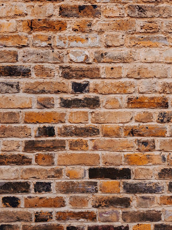 Detailed shot of a weathered brick wall showcasing natural textures and colors. This London-based scene highlights the city's architectural charm and history