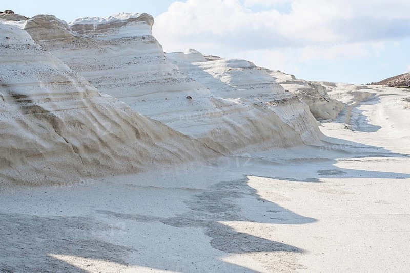 Striking, natural white rock formations at Sarakiniko Beach on the island of Milos, Greece. The smooth, sculptural cliffs and textured sand create a dramatic landscape