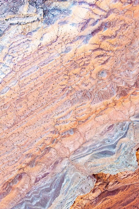 Aerial view of intricate, colorful textures at Vermilion Cliffs National Monument, Arizona, showcasing the natural beauty and geological formations of the desert landscape