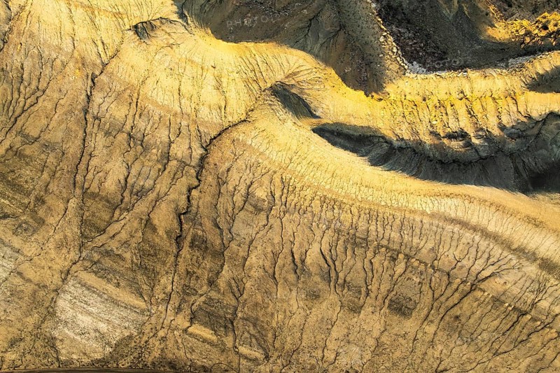 Mesmerizing aerial view of golden sandstone formations in the Utah desert, revealing intricate patterns and textures shaped by natural erosion over centuries